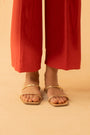A full-length shot of a woman wearing Beyond East's red straight-fit trousers from the 2025 collection.