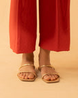 A full-length shot of a woman wearing Beyond East's red straight-fit trousers from the 2025 collection.