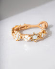 A gold-toned bracelet for women in pakistan with cord band featuring celestial charms including crescent moons and stars with white or pearl-like insets.
