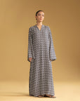 A woman wearing a stylish geometric-print kaftan, a popular long dress in Pakistani fashion.