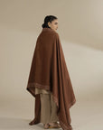 Back/side angle showing shawl length and flow, highlighting the warm brown tone and coverage.