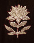 Close-up of gold embroidered floral motif on velvet fabric