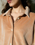 Close-up of velvet collar and neckline detail on camel co-ord shirt.