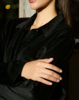 Close-up portrait of model in black velvet co-ord set highlighting collar/neckline.