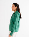 Comfortable green hoodie with a relaxed fit, styled for a minimalist and trendy casual look.