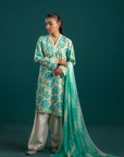 Elegant three piece lawn suit featuring an off-white base with sea blue floral prints, paired with a zigzag chiffon dupatta and dyed cambric trouser – a must-have for summer.