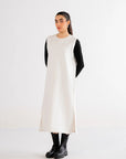 Elegant white maxi dress with layered black sleeves, creating a stylish monochrome ensemble.