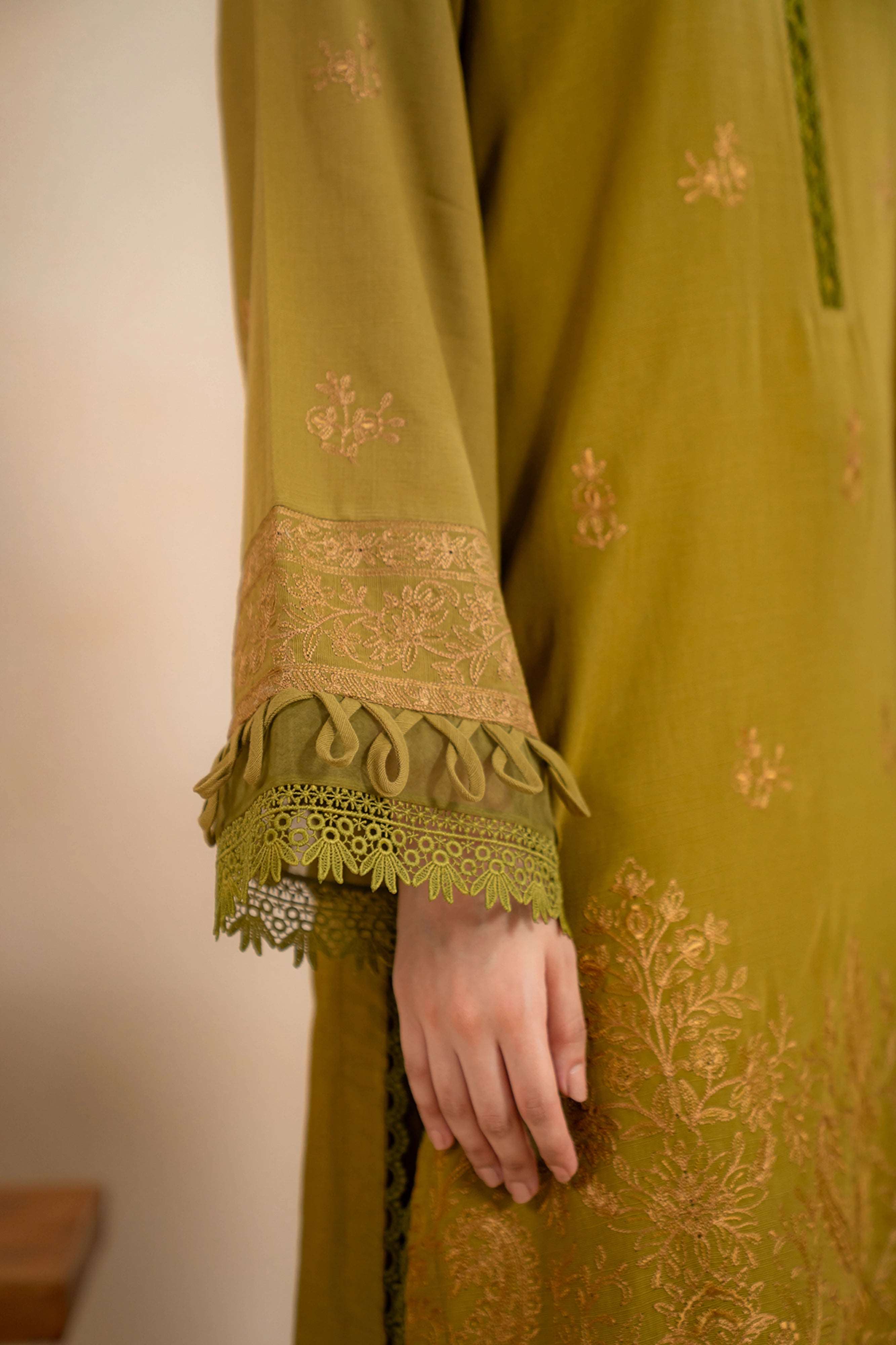 Embroidered sleeve detail with lace trim and velvet tassel