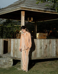 Full-length outdoor shot of camel velvet co-ord set near wooden structure, showing overall silhouette.
