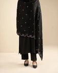 Full-length styling shot showing the shawl worn as a winter wrap with subtle embroidered accents.