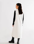 Minimalist white sleeveless maxi dress paired with black boots and black inner sleeves for contrast.