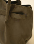 Olive green soft suede shoulder tote bag with structured base and long handles in studio lighting.