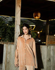 Outdoor portrait in tan velvet co-ord set highlighting relaxed collar and button placket.