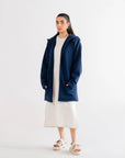 Relaxed-fit navy blue cardigan, paired with a white dress and sandals, ideal for a comfortable and stylish outfit.