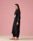 Shop black two-piece co ord set for women in Pakistan with white floral embroidery on kurta and classic black trousers