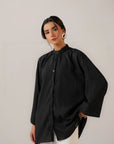 Stylish oversized black shirt for women paired with casual white pants