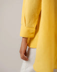 Trendy yellow oversized shirt women - casual button down blouse with rolled sleeves styling