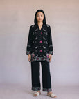 Woman wearing a black embroidered co-ord set with colorful floral embroidery and wide leg palazzo trousers from Beyond East Pakistani fashion collection