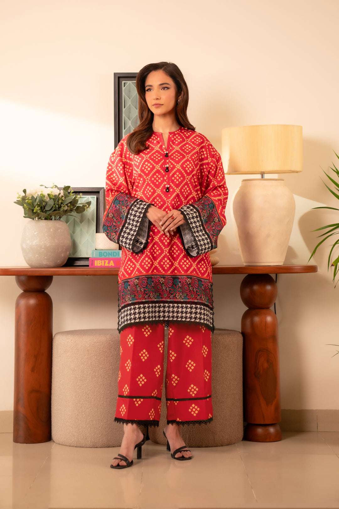 2 piece printed cambric suit – bold burnt red kurta with black and multicolor border, paired with matching trousers.
