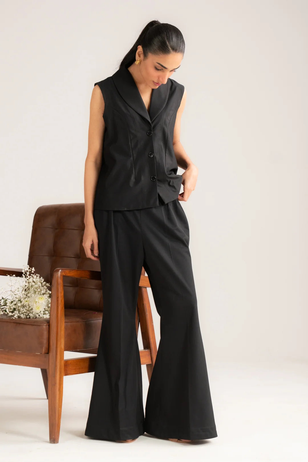 Angled front view of black 2 piece vest set with tailored top and wide-leg trousers
