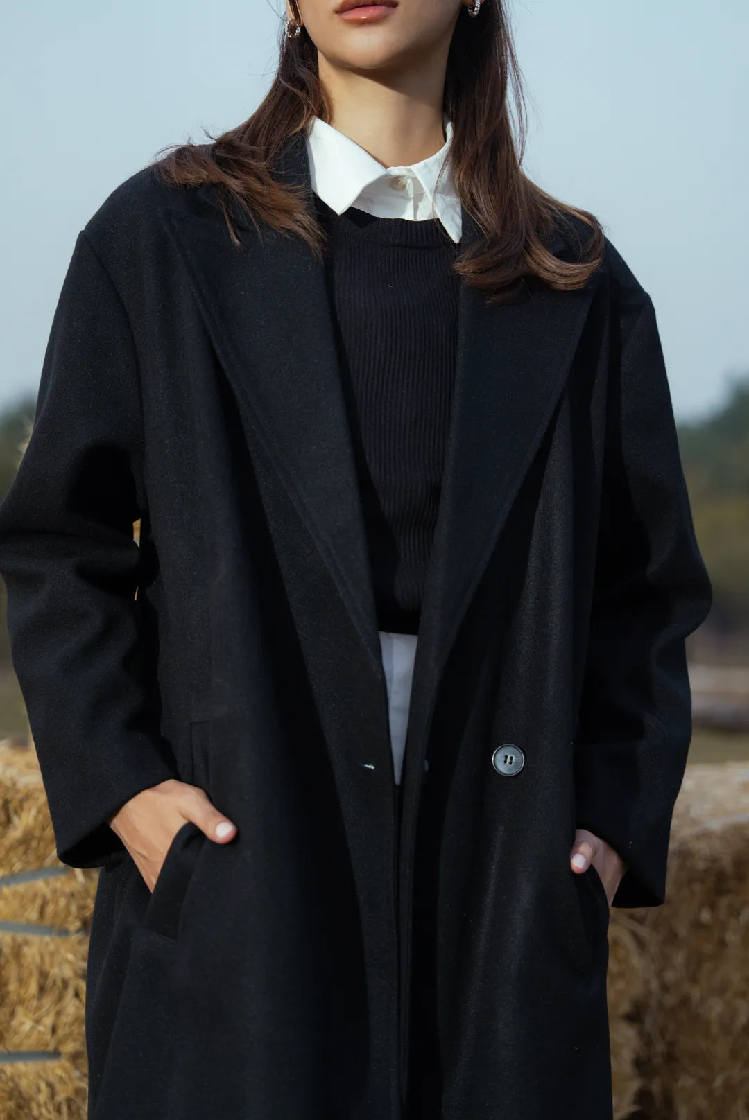 Back view of women’s black long coat, long hem for winter layering