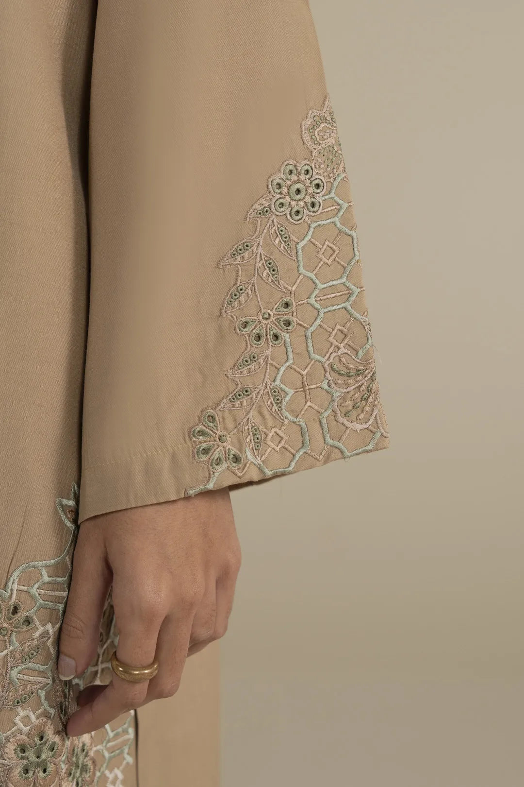 Beige embroidered kurta neckline close-up with subtle stitching and neat placket.