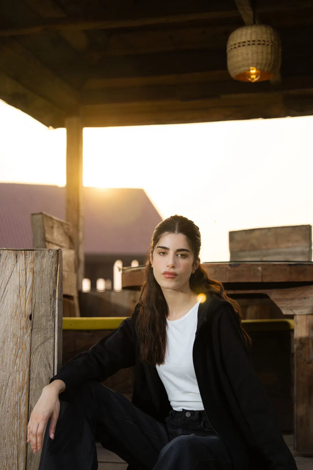 Black zip-up hoodie layered outfit in warm evening light