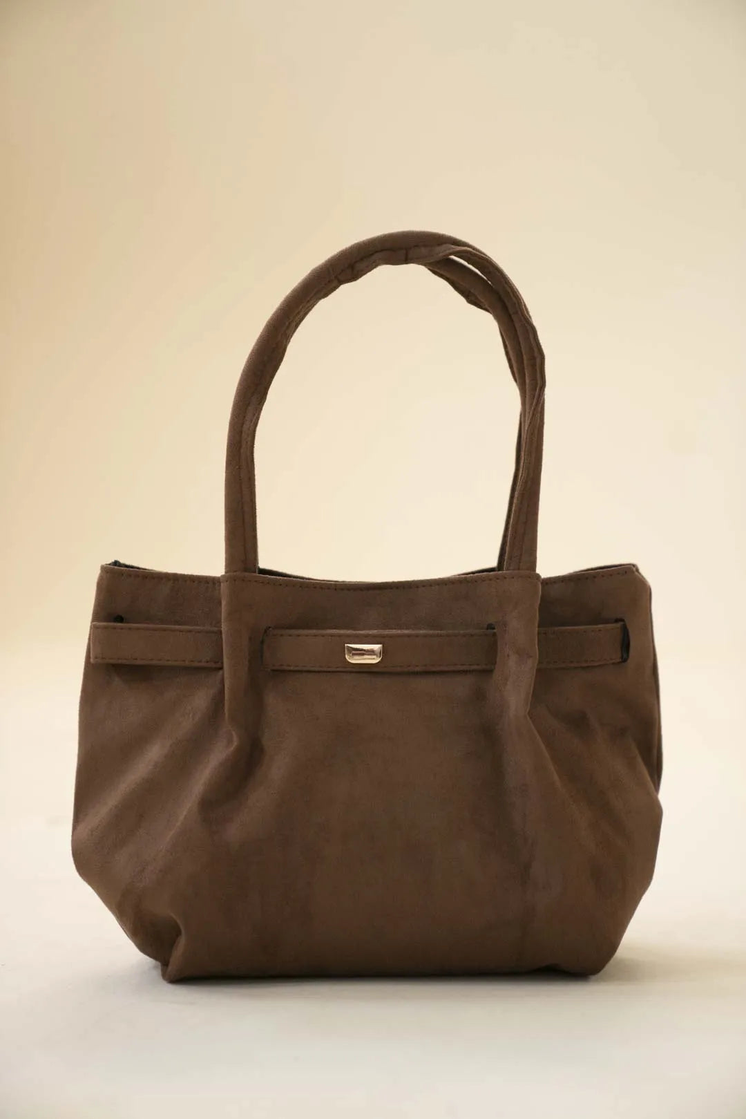 Brown slouchy handbag with long shoulder handles and a soft, roomy silhouette in studio lighting