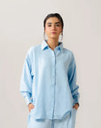 Casual everyday style with a relaxed-fit light blue ladies poplin shirt, unbuttoned over a white cami for effortless layering