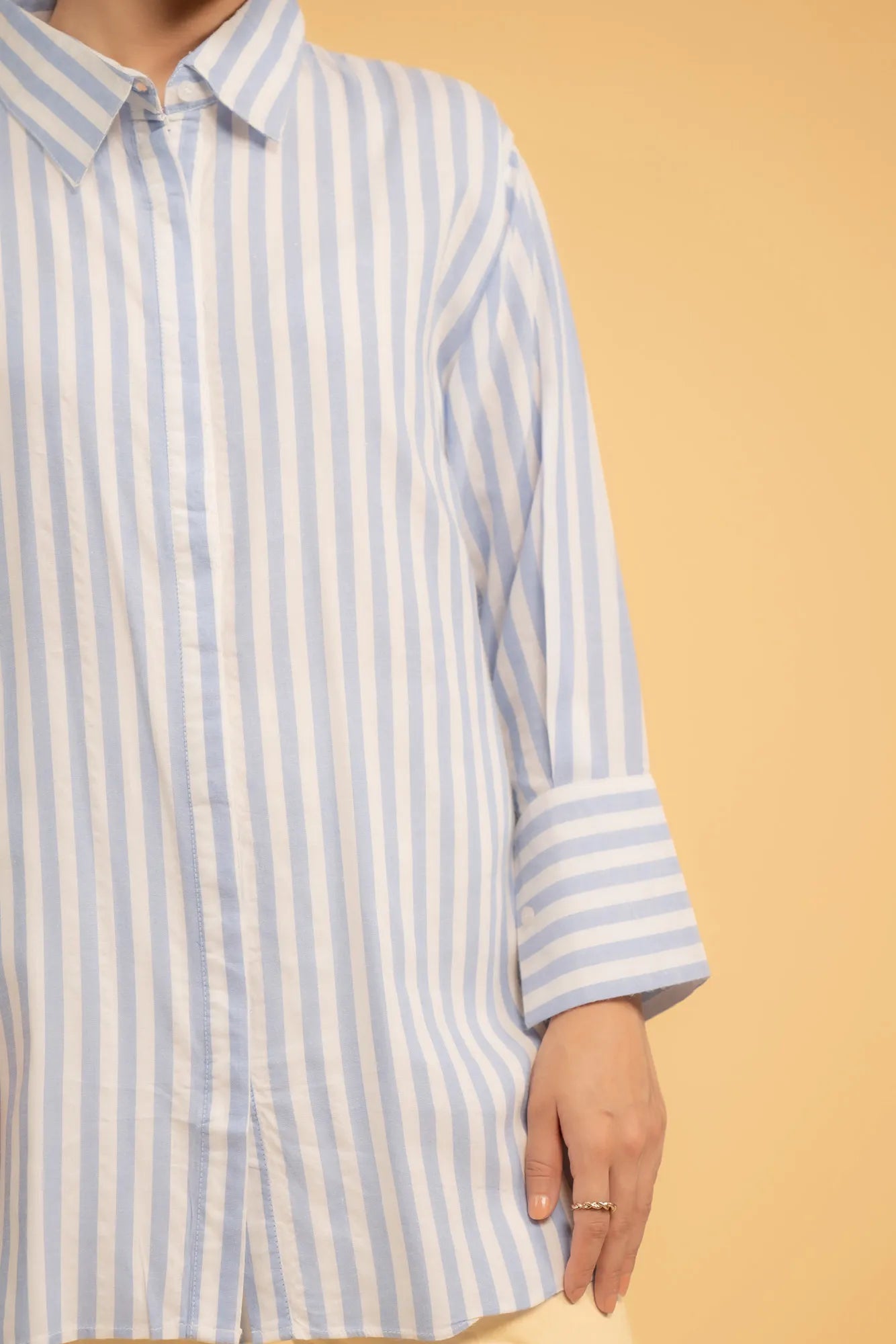 Casual outfit featuring a striped long shirt and white trousers, a perfect modern Pakistani style