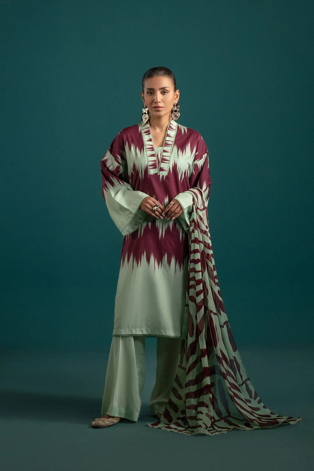 Chic apple green lawn suit with bold maroon ikkat prints, paired with a modern abstract chiffon dupatta – a statement look for summer fashion.
