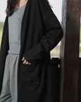 Close-up angle highlighting the black cardigan front pocket and open-front design.