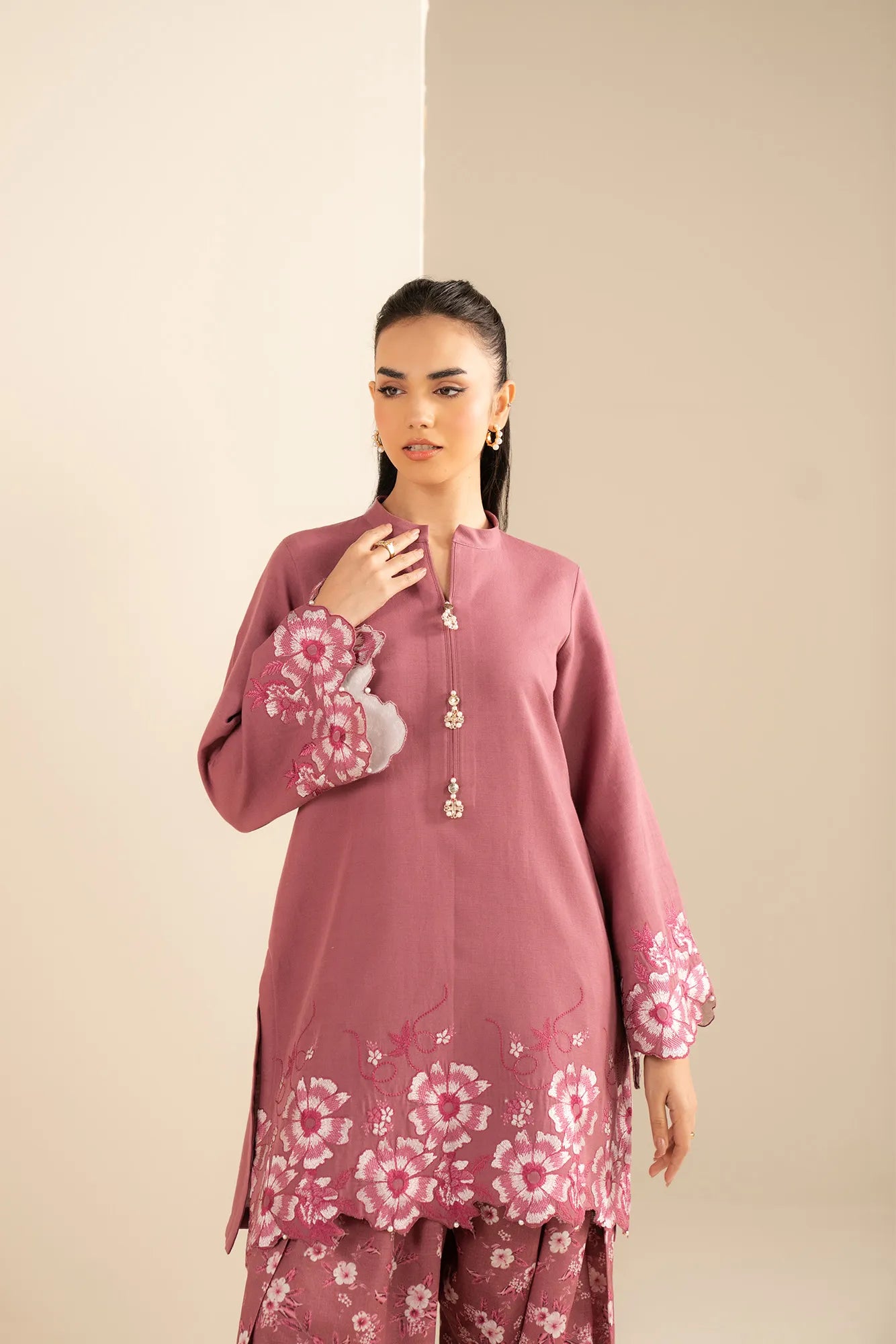 Close-up embroidery detail on pink khaddar shirt front