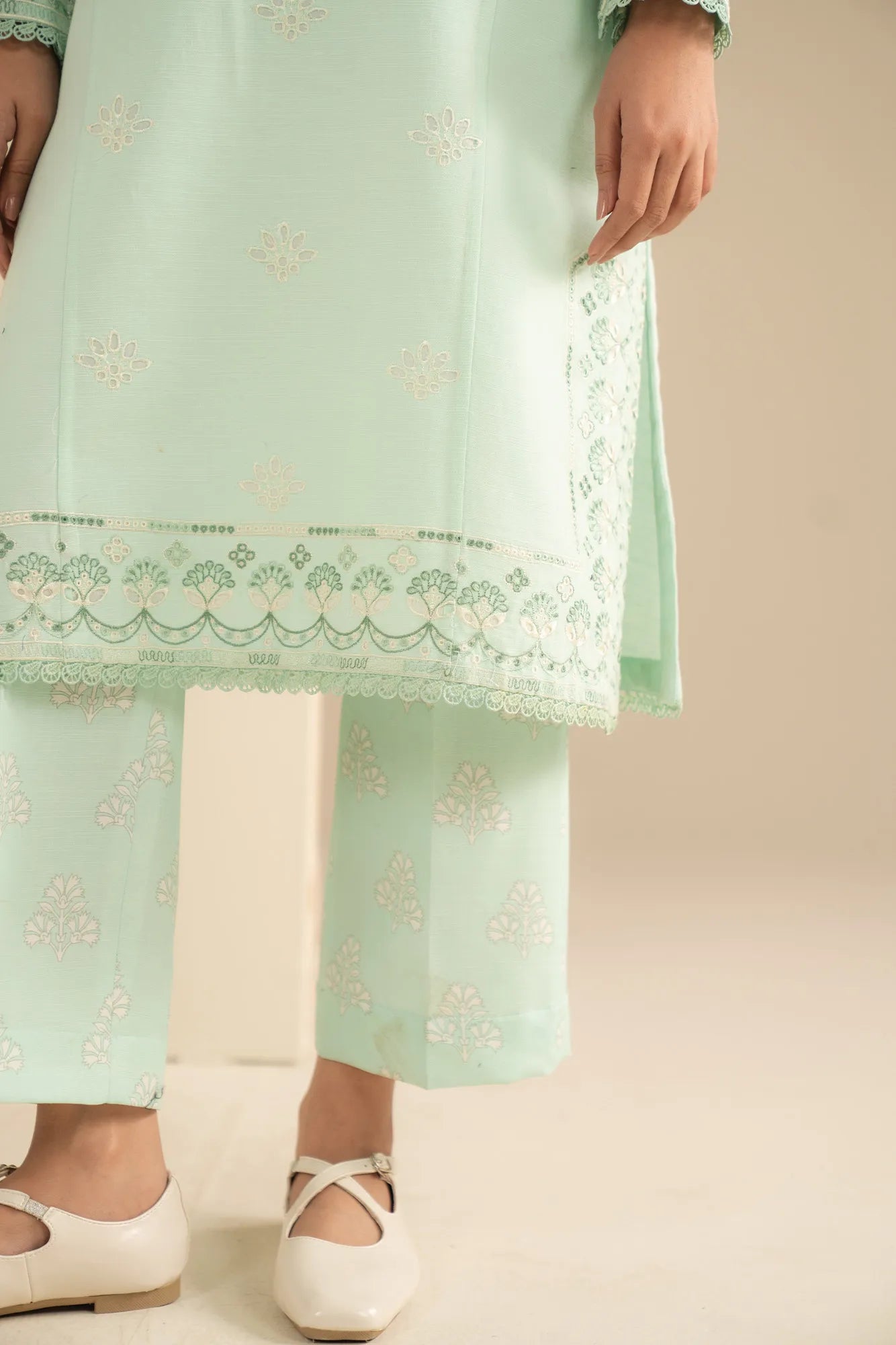 Close-up embroidery detail on sea green khaddar shirt neckline