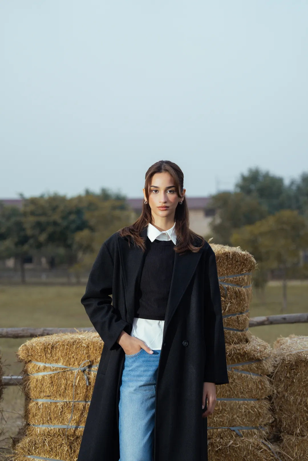 Close-up of black coat collar and front opening, clean minimalist finish