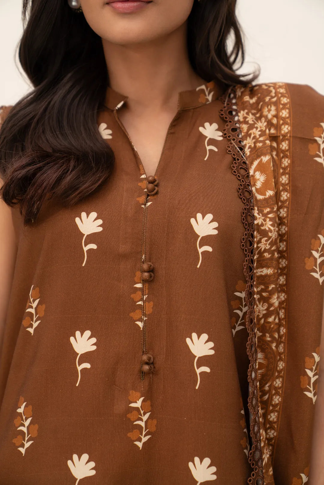 Close-up of brown printed linen shirt showing neckline and motif detail