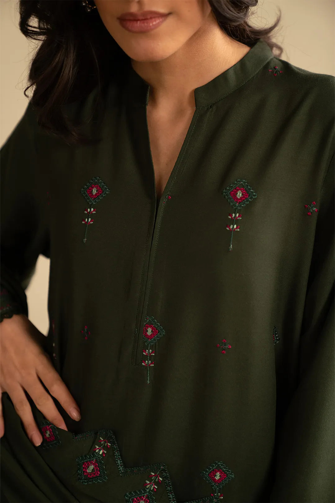 Close-up of deep green embroidered linen kurta front showing delicate motif placement and neckline detail.