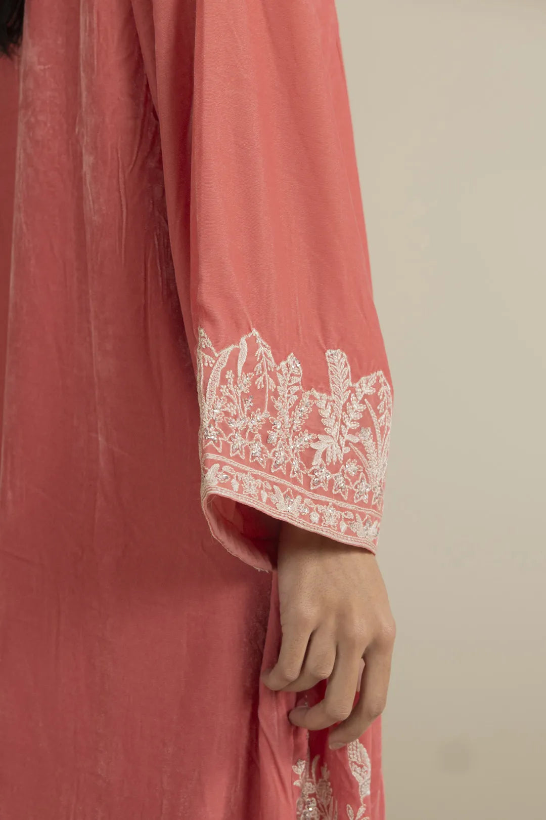 Close-up of embroidered neckline on peach velvet kaftan
