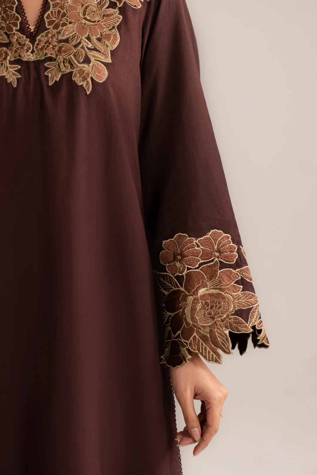 Close-up of embroidered sleeve border on dark brown cambric shirt