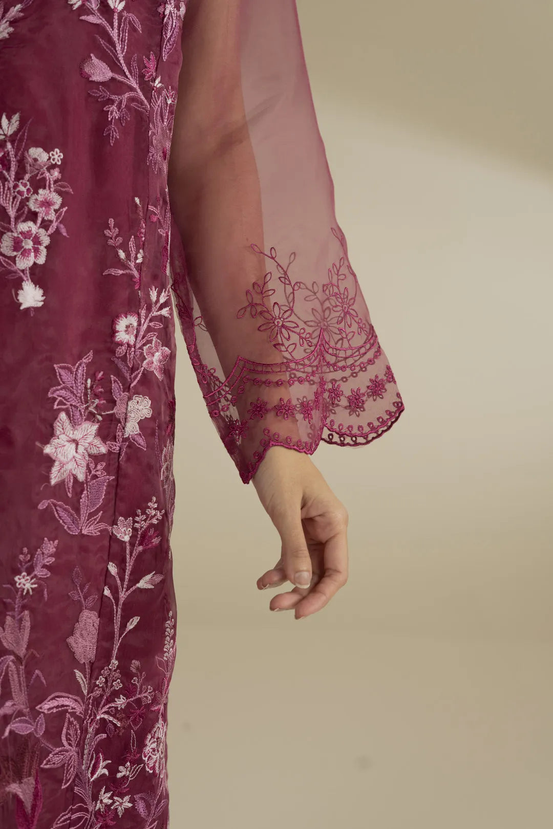 Close-up of embroidered sleeve detail on maroon organza