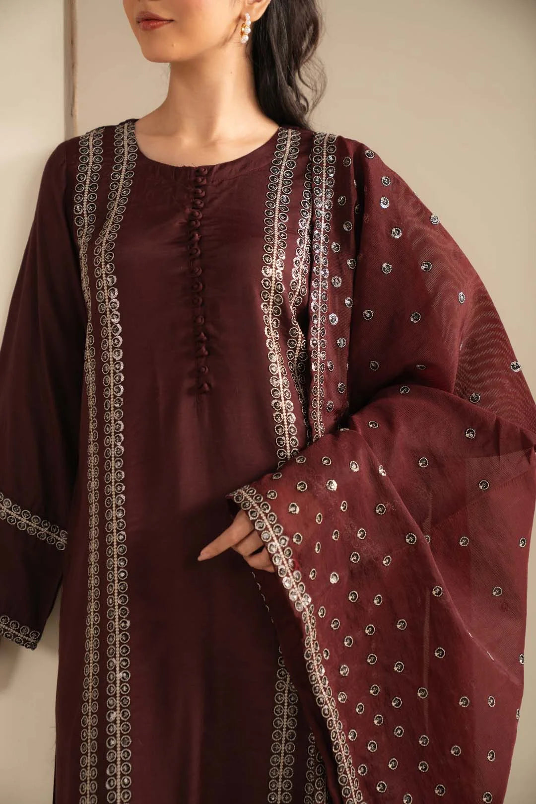 Close-up of maroon raw silk shirt front showing neckline and embellished detailing.