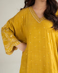 Close-up of mustard kaftan neckline and sleeve embroidery detail