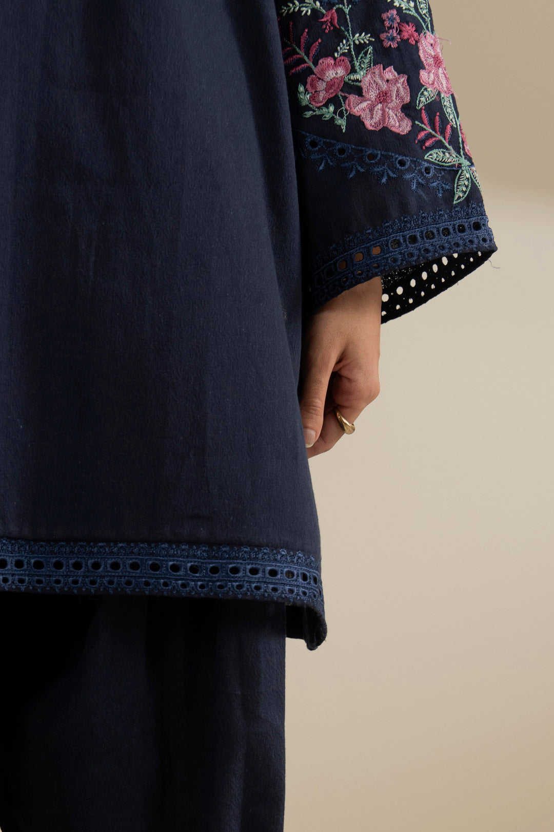 Close-up of navy blue trouser/hem finish showing clean stitching and fabric texture.