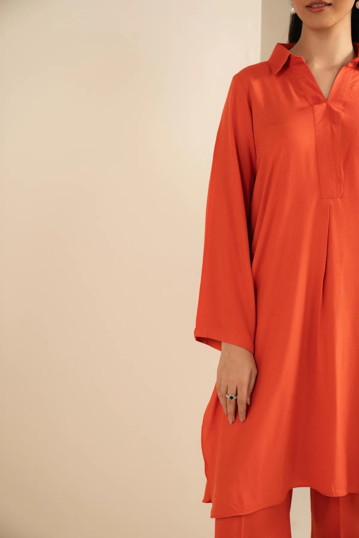Close-up of orange long top co-ord with clean neckline detail