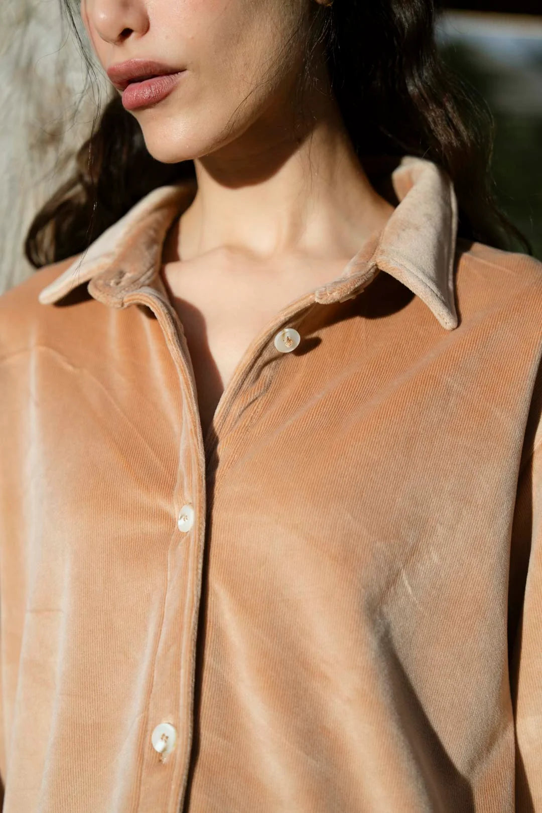 Close-up of velvet collar and neckline detail on camel co-ord shirt.