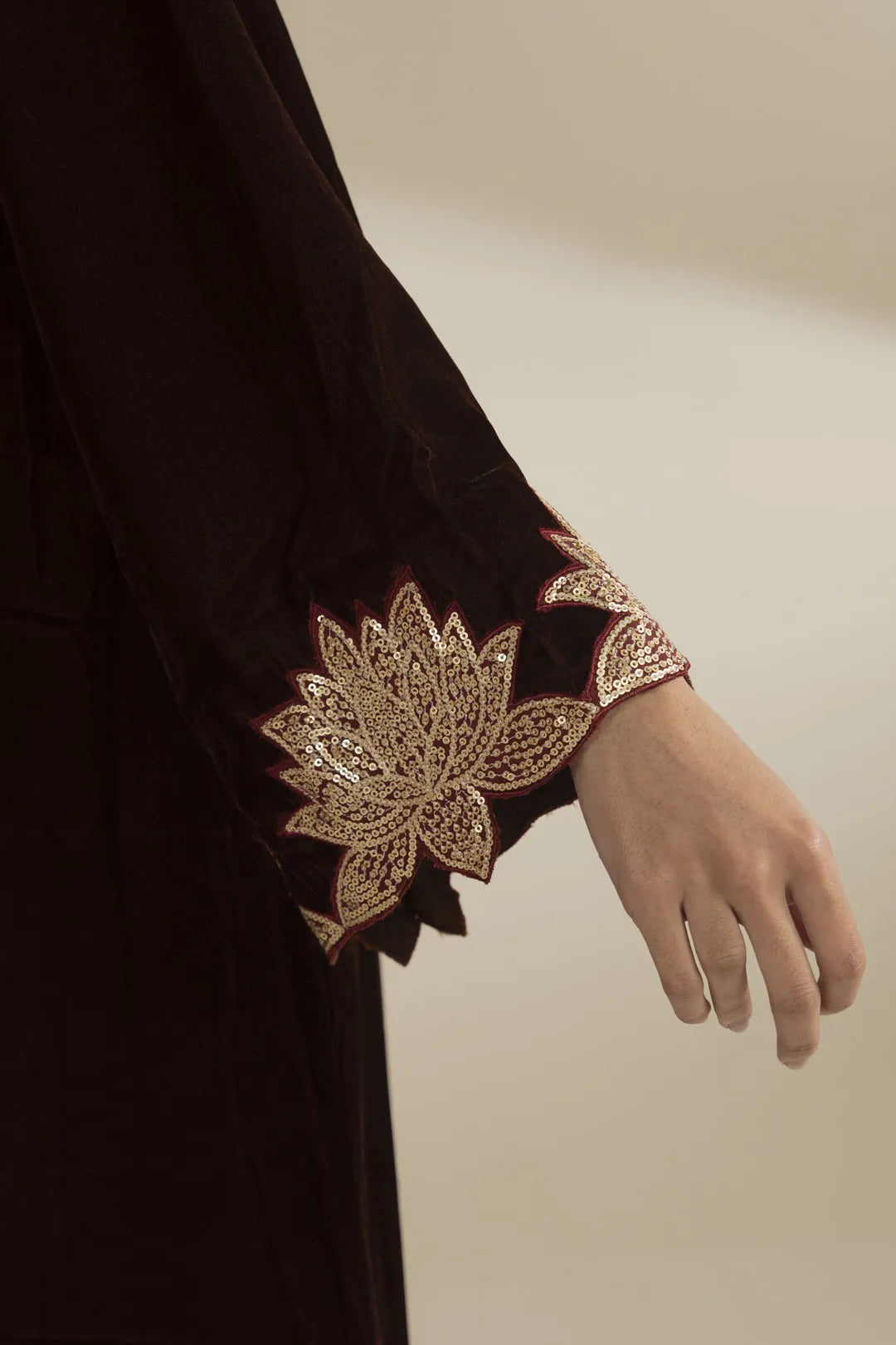Close-up of velvet kaftan sleeve showing gold embroidered cuff detail