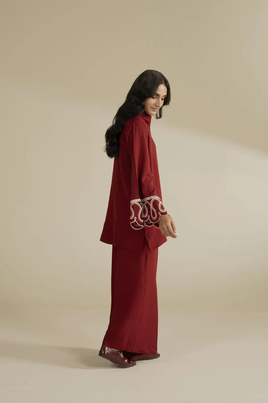 Close-up of white embroidery detail on red sleeve cuff