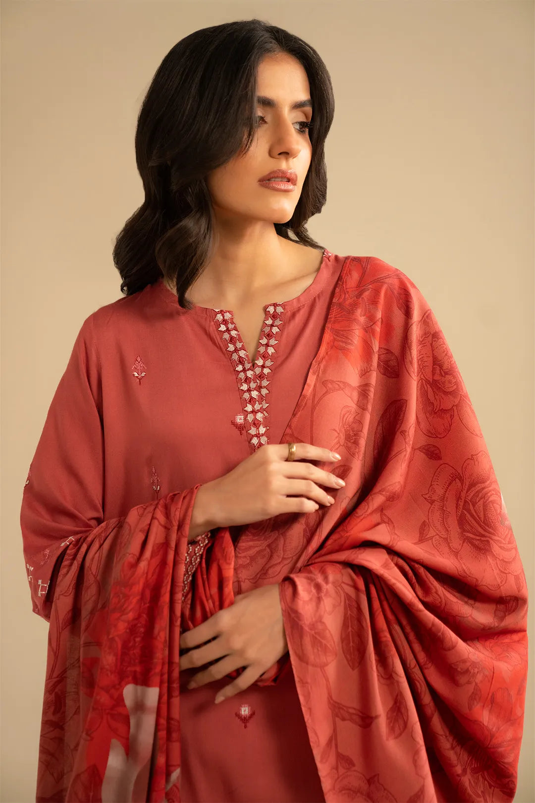 Close shot of the kurta neckline embroidery in warm orange tones with delicate thread detailing.
