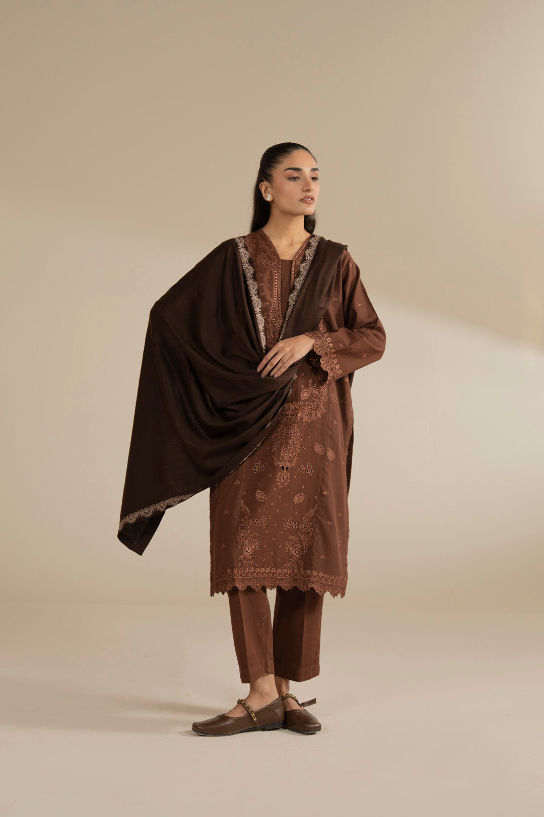 Dark brown yarn dyed shawl draped over a brown embroidered outfit, shown as a complete winter look.