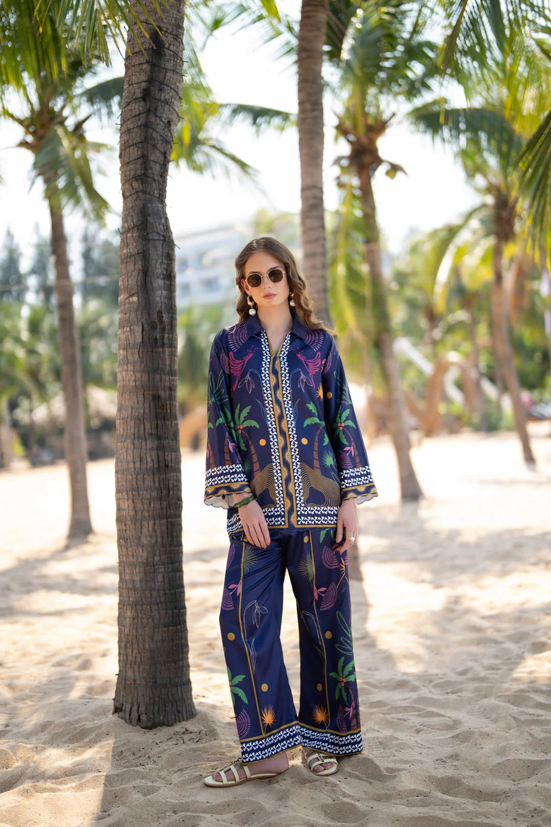 Front full-length view of woman wearing a blue printed poly satin co-ord set on the beach